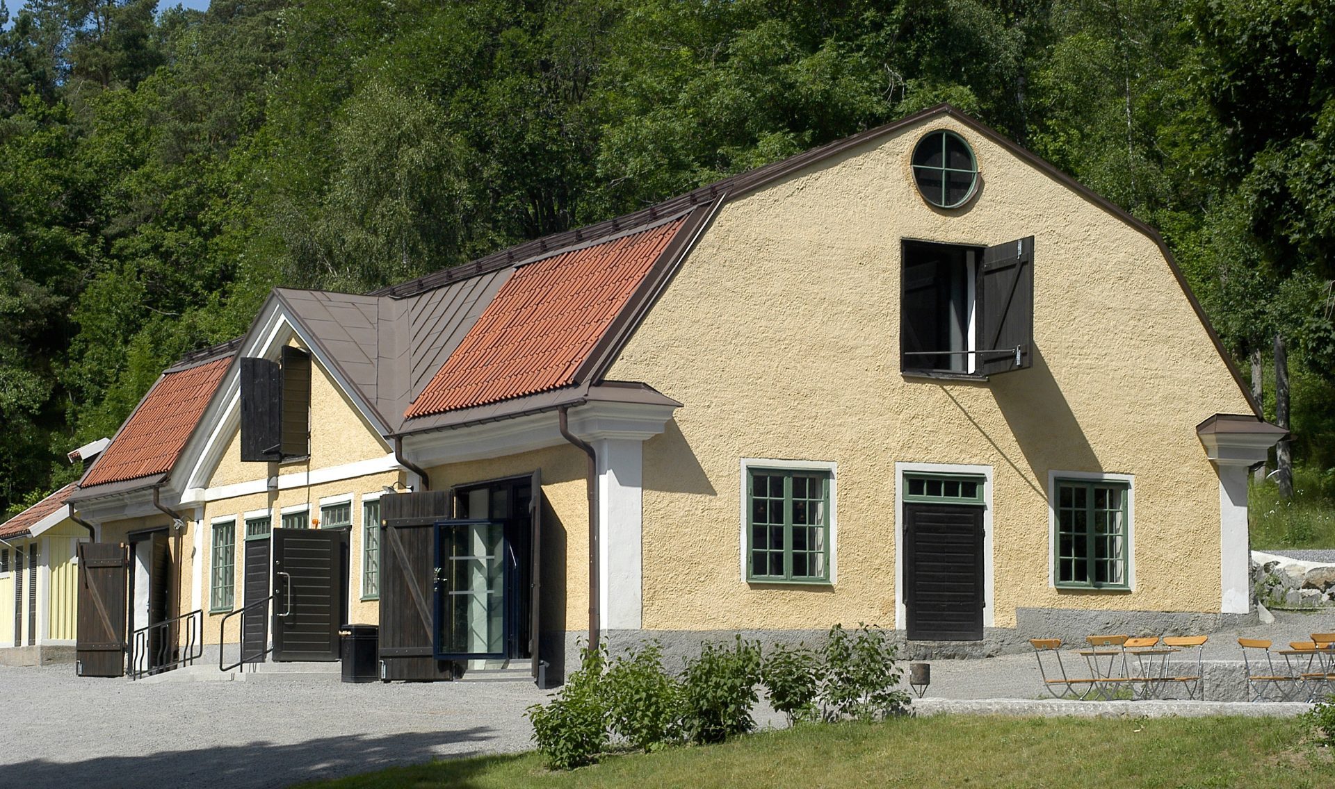 A yellow building with nature surrounding it