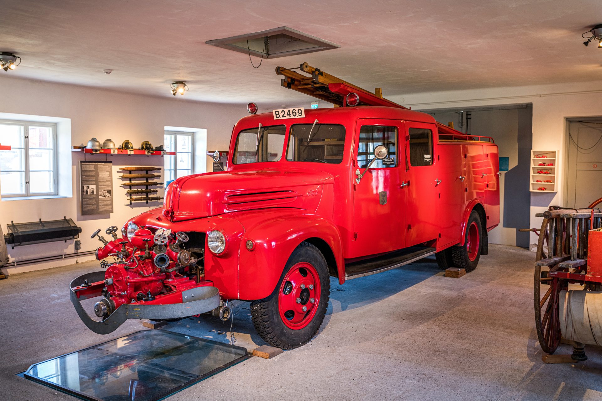 Äldre röd brandbil inne i Spruthuset på Tumba bruk. 