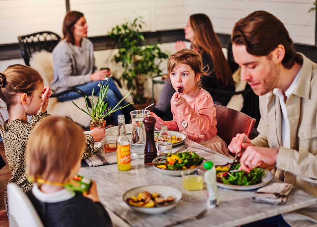 En familj äter lunch på ett café