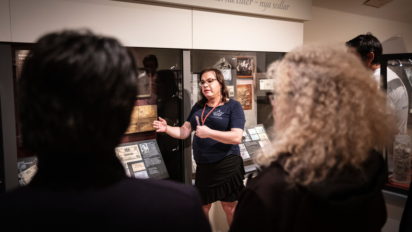 A museum educator talking infront of a group.