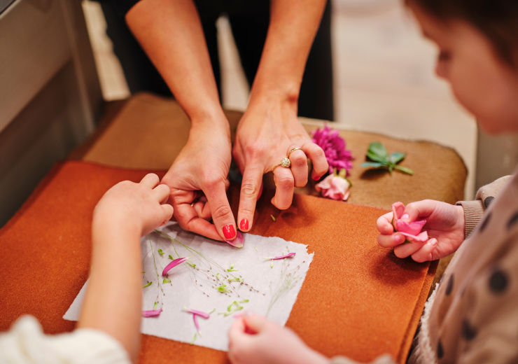 Vuxna och barn som lägger blommor på papper