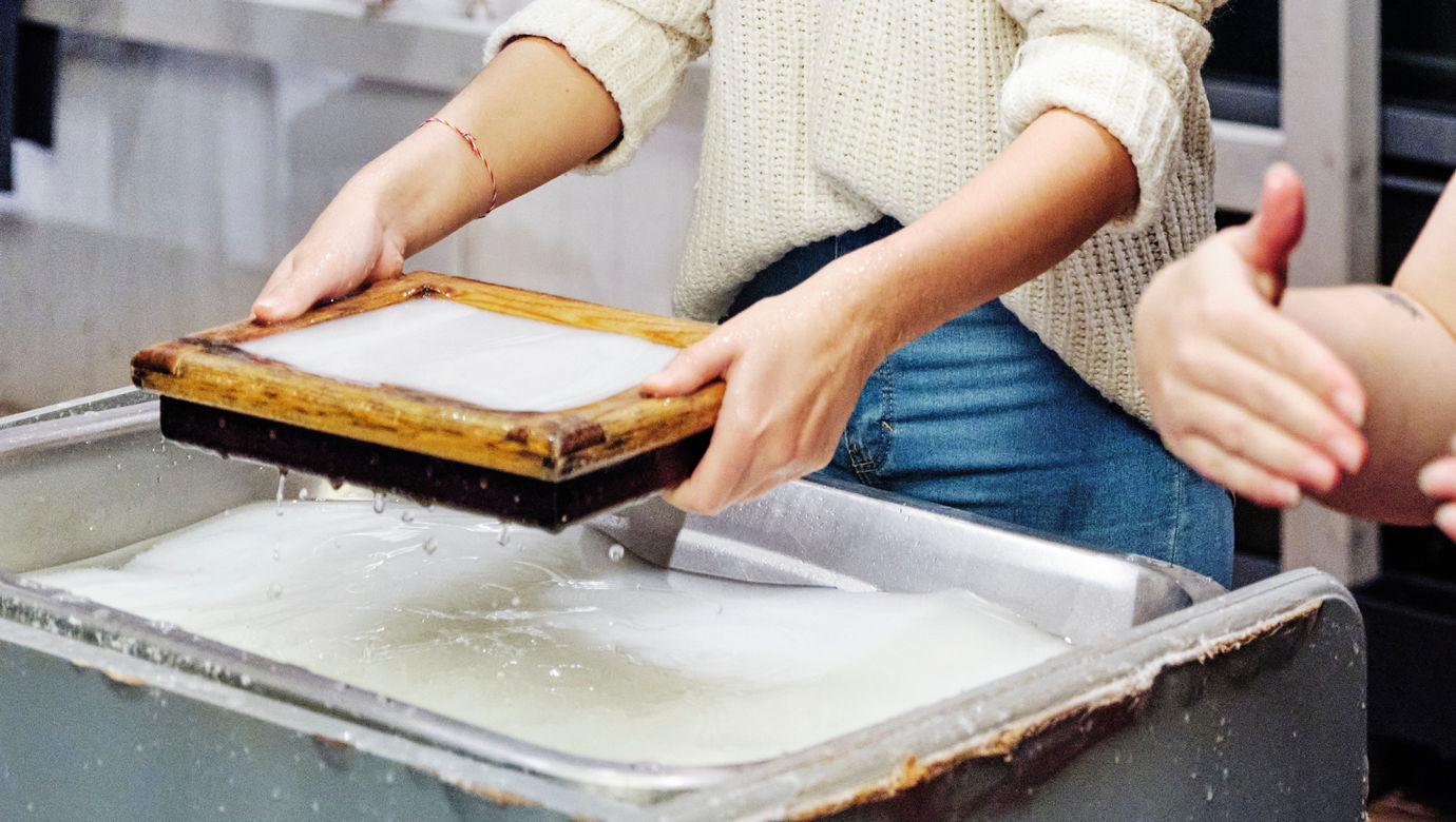 A person making their own paper by hand.