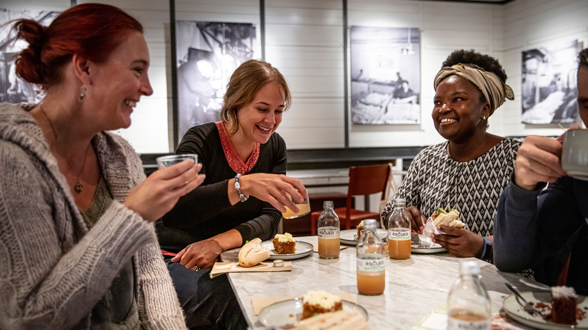 People sitting in the café, talking and laughing. 