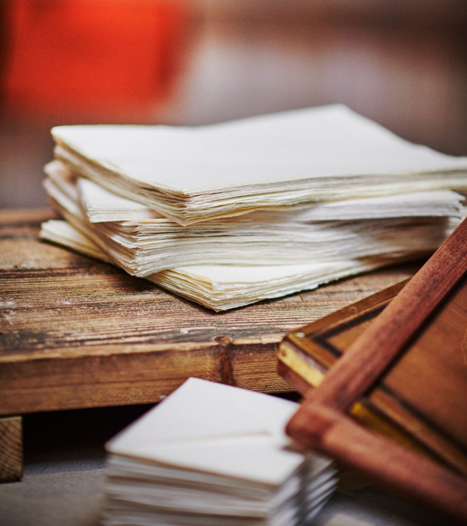 Stacks of paper, envelopes and wooden frames.