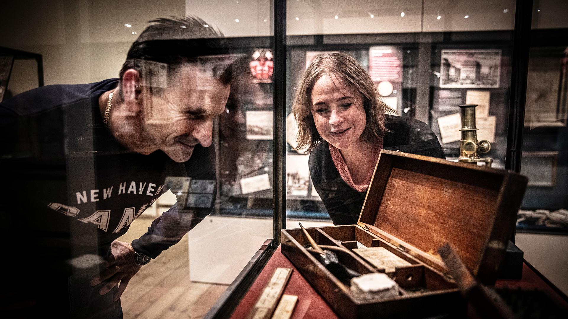 Two visitors looking at an exhibition case.
