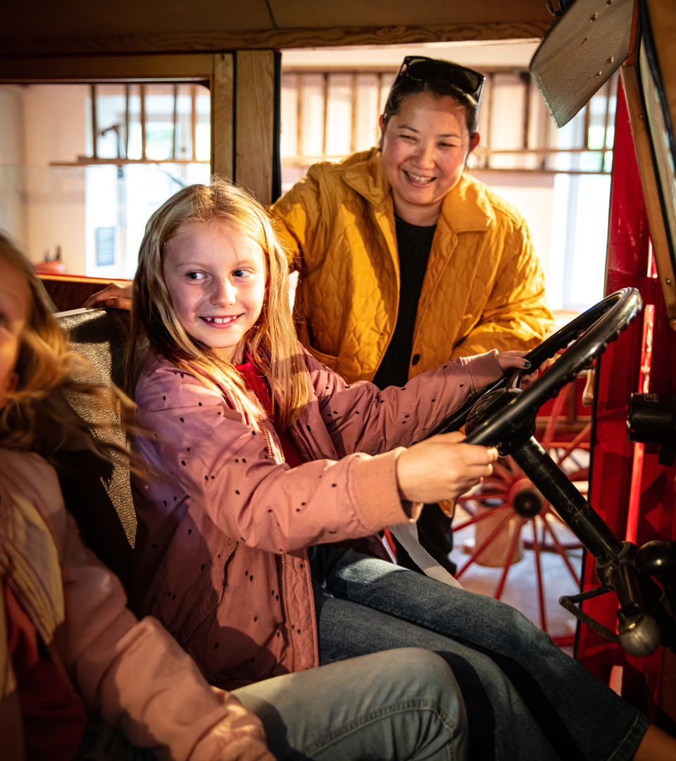 Child and adult driving a fire truck