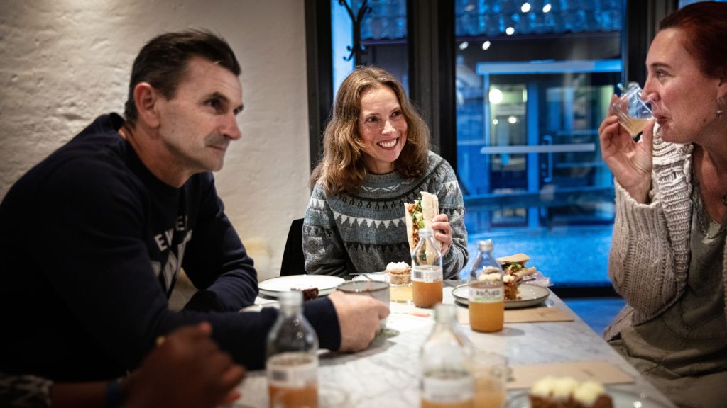 Vuxna i stickade tröjor fikar i restaurangen