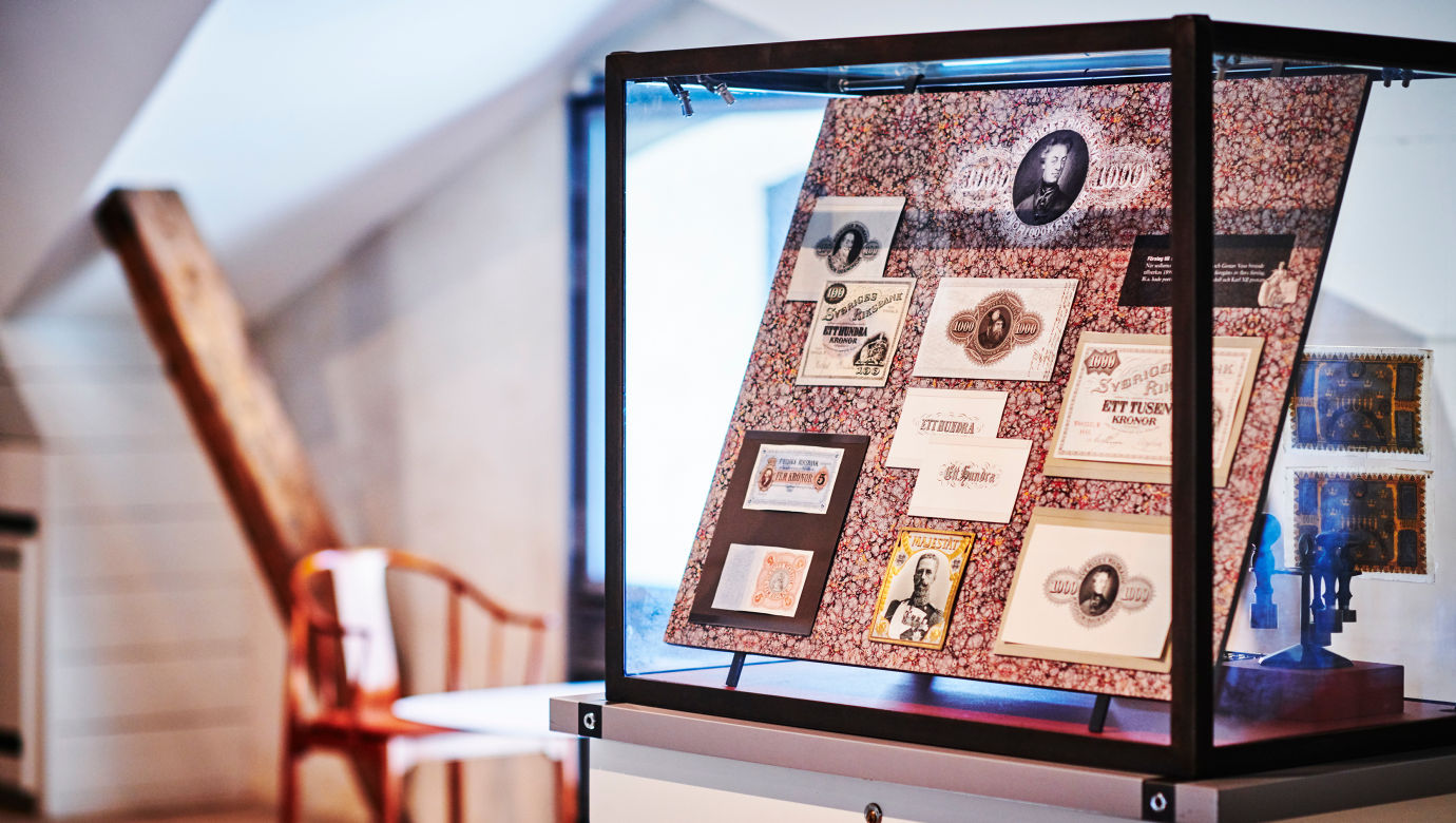 An exhibition case showing old bank notes. 