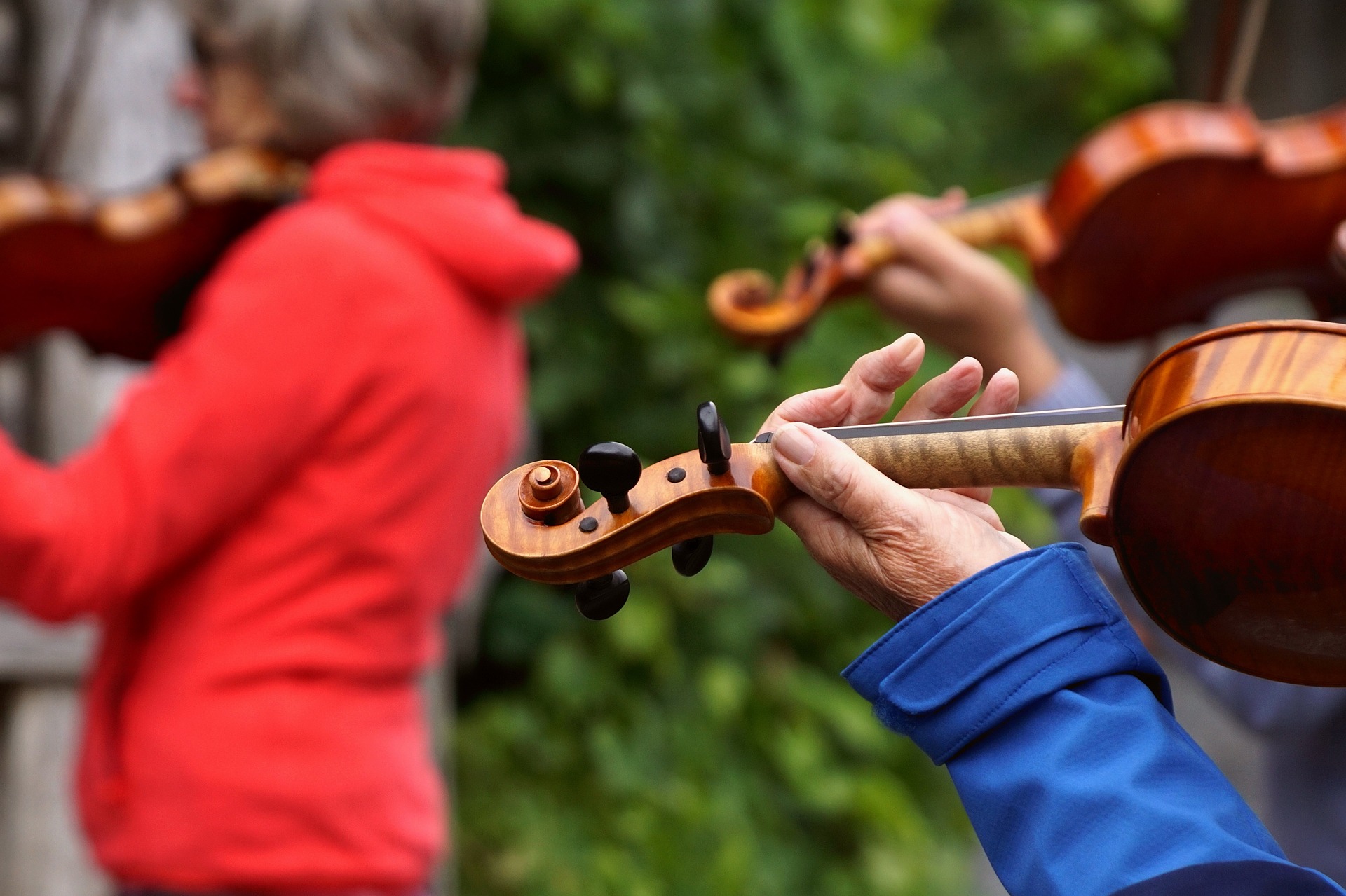 Personer spelar fiol utomhus