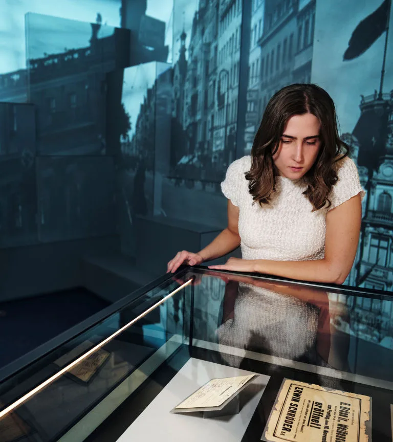 A person looks at an exhibition stand in the Seven Lives exhibition.