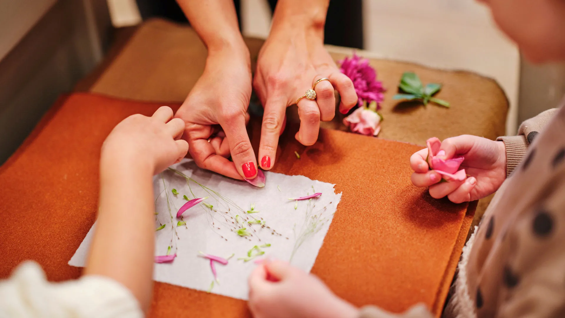 Adult and children laying flowers on handmade paper