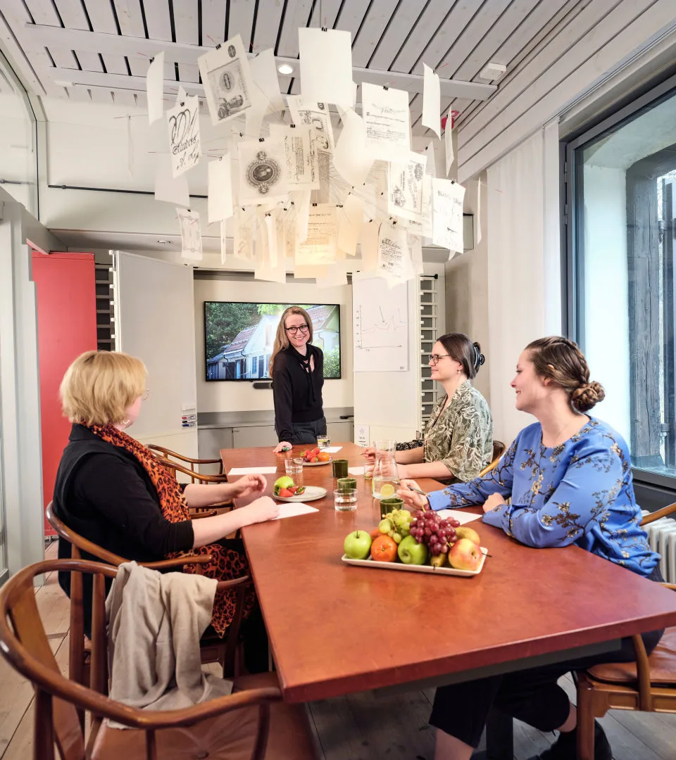 People meeting around a table with fruit and coffee